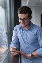 Image showing Businessman Standing In A Modern Building Near The Window With P