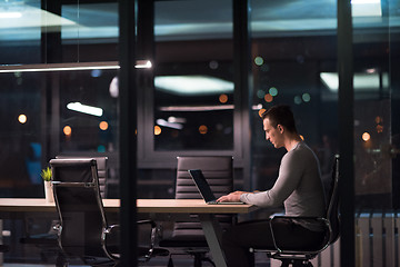 Image showing man working on laptop in dark office