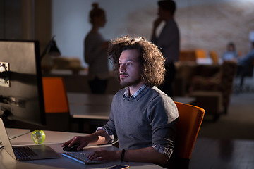 Image showing man working on computer in dark office