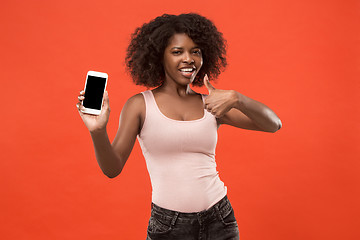 Image showing Portrait of a confident casual afro girl showing blank screen mobile phone isolated over red background
