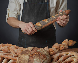 Image showing Men\'s hands hold a baguette