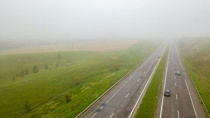 Image showing Aerial view panoramic view of the foggy road with cars around the field. Photo from the drone