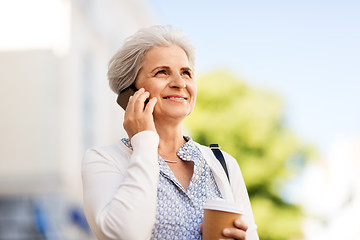 Image showing senior woman calling on smartphone in city