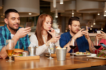 Image showing friends with smartphones at restaurant