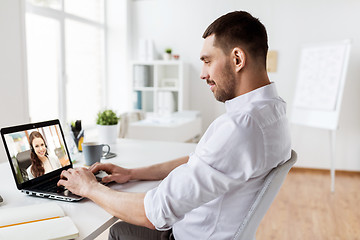 Image showing businessman having video call on laptop at office