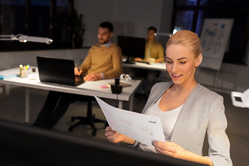 Image showing designer working with papers at night office