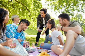 Image showing friends with drinks and food at picnic in park