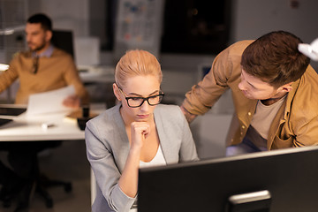 Image showing business team with computer working late at office