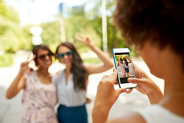 Image showing woman photographing her friends in summer park