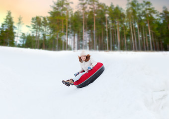 Image showing happy teenage girl sliding down hill on snow tube