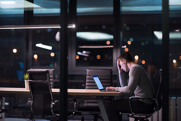 Image showing man working on laptop in dark office