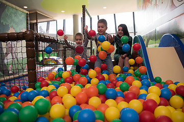 Image showing Young mom with her kids in a children\'s playroom