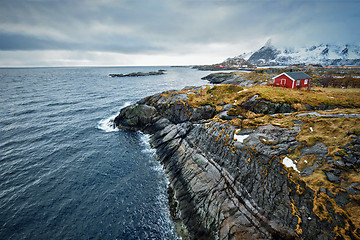 Image showing Clif with traditional red rorbu house on Lofoten Islands, Norway