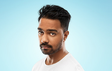 Image showing sad young indian man over blue background