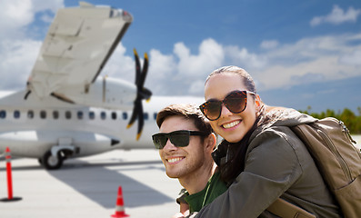 Image showing couple of tourists with backpacks over plane