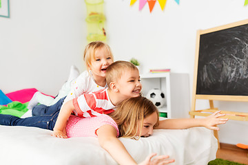 Image showing happy little kids having fun in bed at home