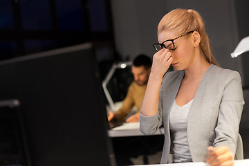 Image showing businesswoman rubbing tired eyes at night office