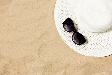 Image showing straw hat and sunglasses on beach sand