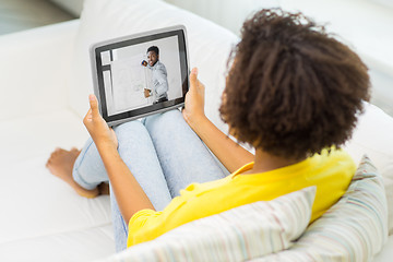 Image showing woman watching webinar on tablet computer at home