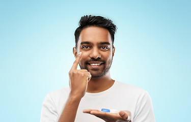 Image showing young indian man applying contact lenses