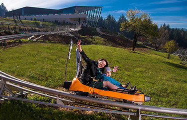 Image showing young mother and son driving alpine coaster