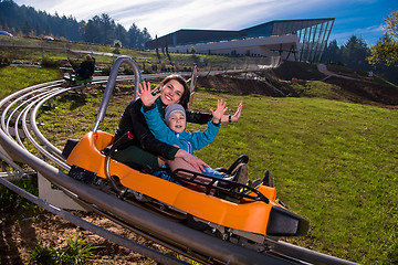 Image showing young mother and son driving alpine coaster