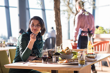 Image showing young woman  having lunch at restaurant