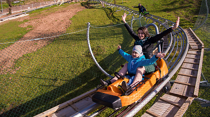 Image showing young mother and son driving alpine coaster