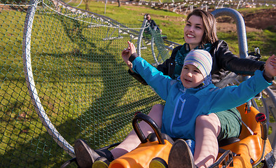 Image showing young mother and son driving alpine coaster