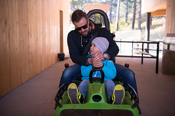 Image showing young father and son driving alpine coaster