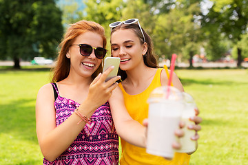 Image showing teenage girls with smartphone and shakes in park