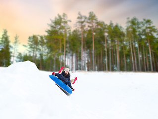 Image showing happy teenage girl sliding down hill on snow tube