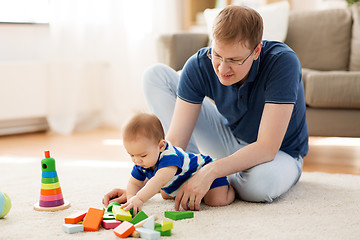 Image showing happy father with baby son playing toys at home