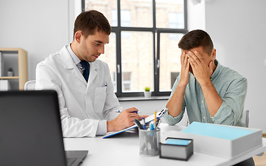 Image showing doctor with clipboard and male patient at hospital