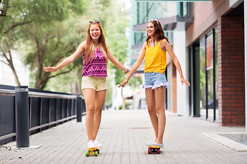 Image showing teenage girls riding skateboards in city