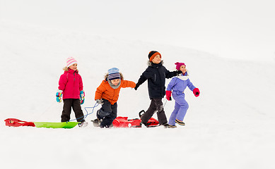 Image showing happy little kids with sleds in winter