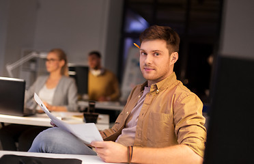 Image showing man with papers working at night office