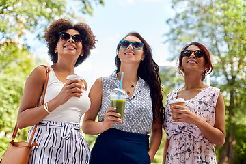 Image showing happy women or friends with drinks at summer park