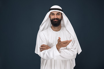 Image showing Arabian saudi businessman on dark blue studio background