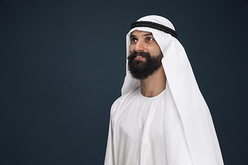 Image showing Arabian saudi businessman on dark blue studio background