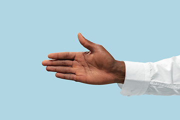 Image showing Male hand demonstrating a gesture of inviting isolated on blue background