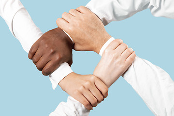Image showing Male and female hands holding isolated on blue studio background