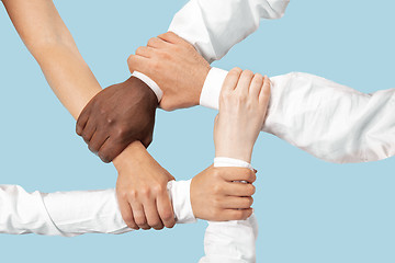 Image showing Male and female hands holding isolated on blue studio background