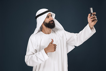 Image showing Arabian saudi man on dark blue studio background