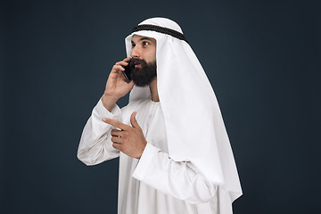 Image showing Arabian saudi man on dark blue studio background