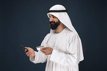 Image showing Arabian saudi man on dark blue studio background