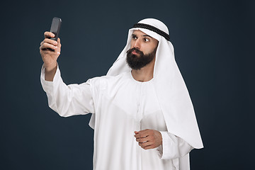 Image showing Arabian saudi man on dark blue studio background