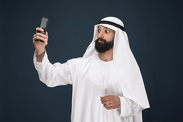 Image showing Arabian saudi man on dark blue studio background