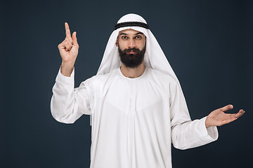 Image showing Arabian saudi man on dark blue studio background