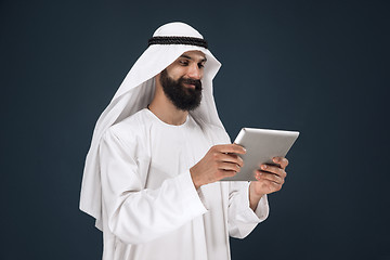 Image showing Arabian saudi businessman on dark blue studio background